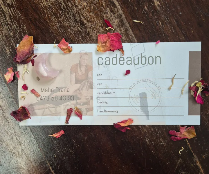 Cadeaubon van Maha Prana op een houten tafel met gedroogde rozenblaadjes